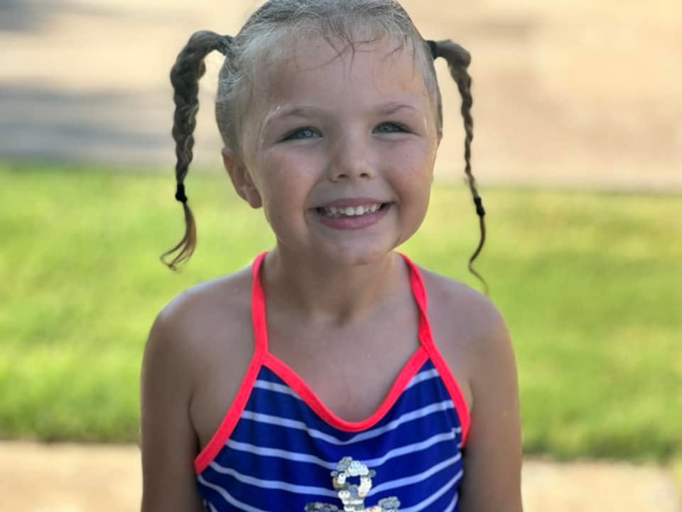Child with braided pigtails smiling