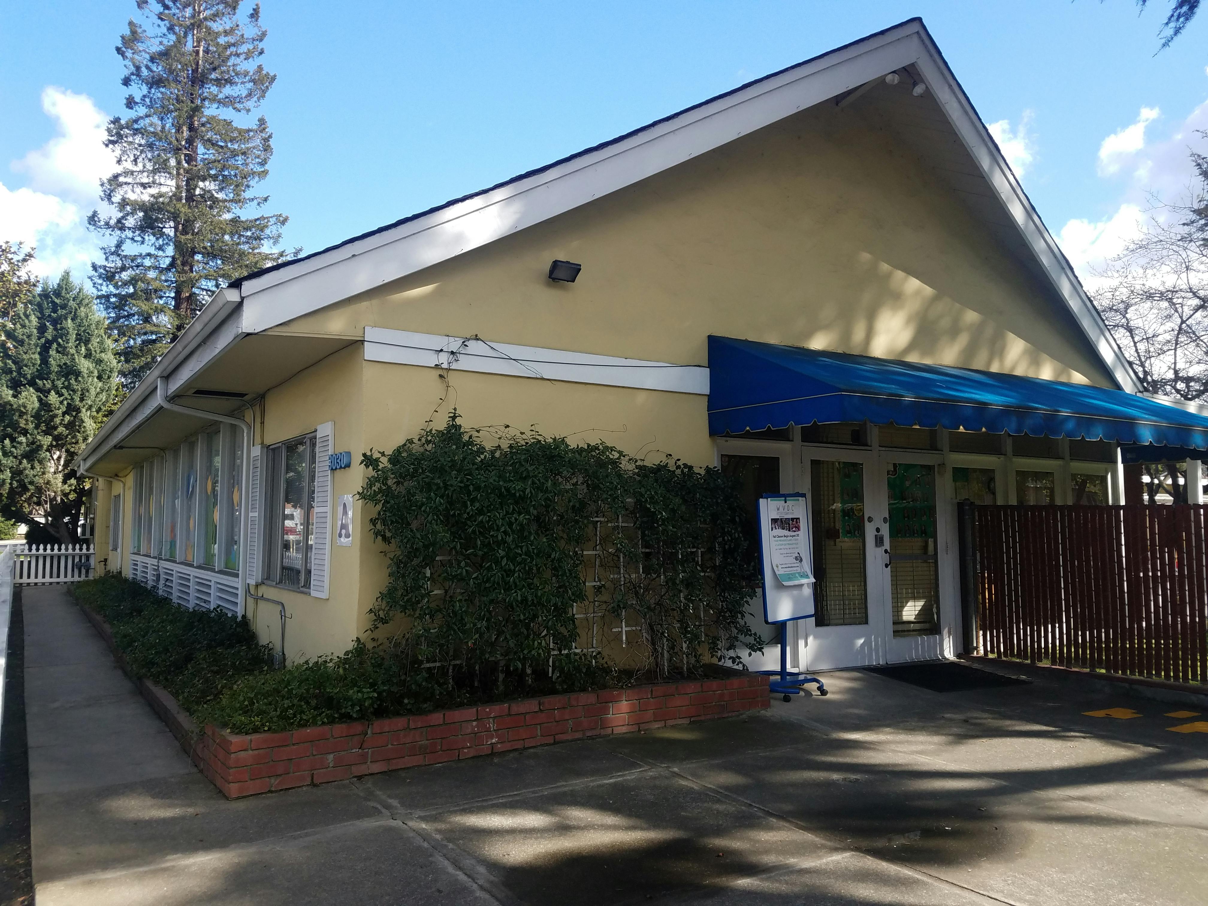 Yellow building with a blue awning over the entrance