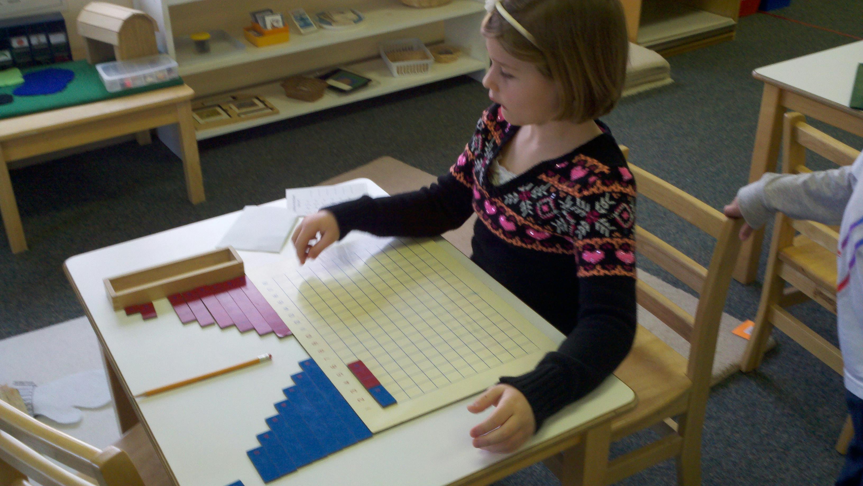 Child at a desk working with learning materials