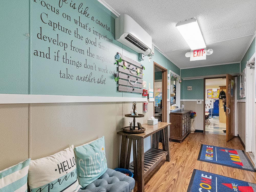 Hallway with a teal wall, wooden console table, and two open doorways