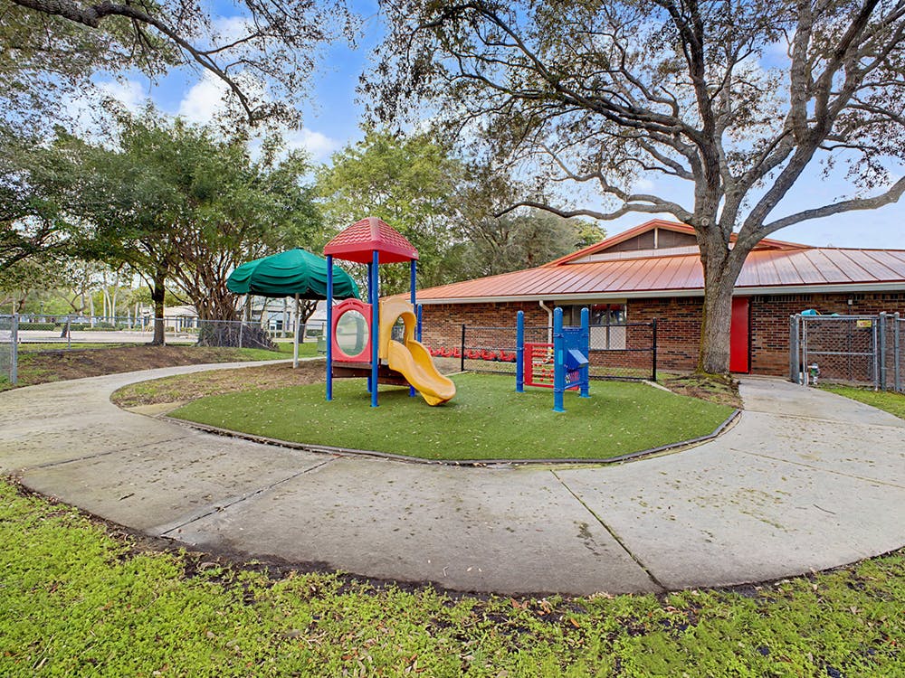 A colorful playground with slides and other equipment on artificial turf