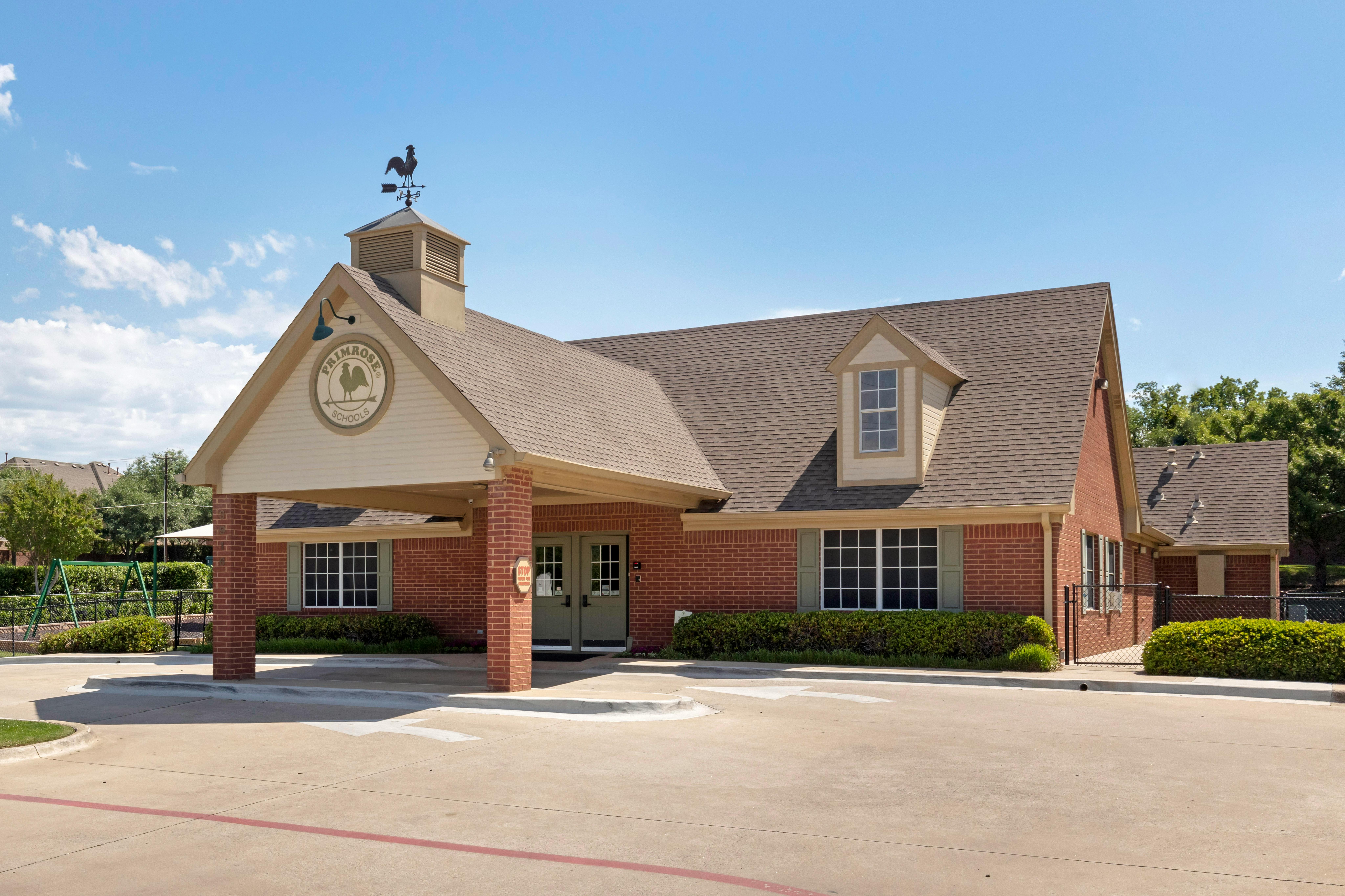 Primrose Schools building with a weathervane and playground