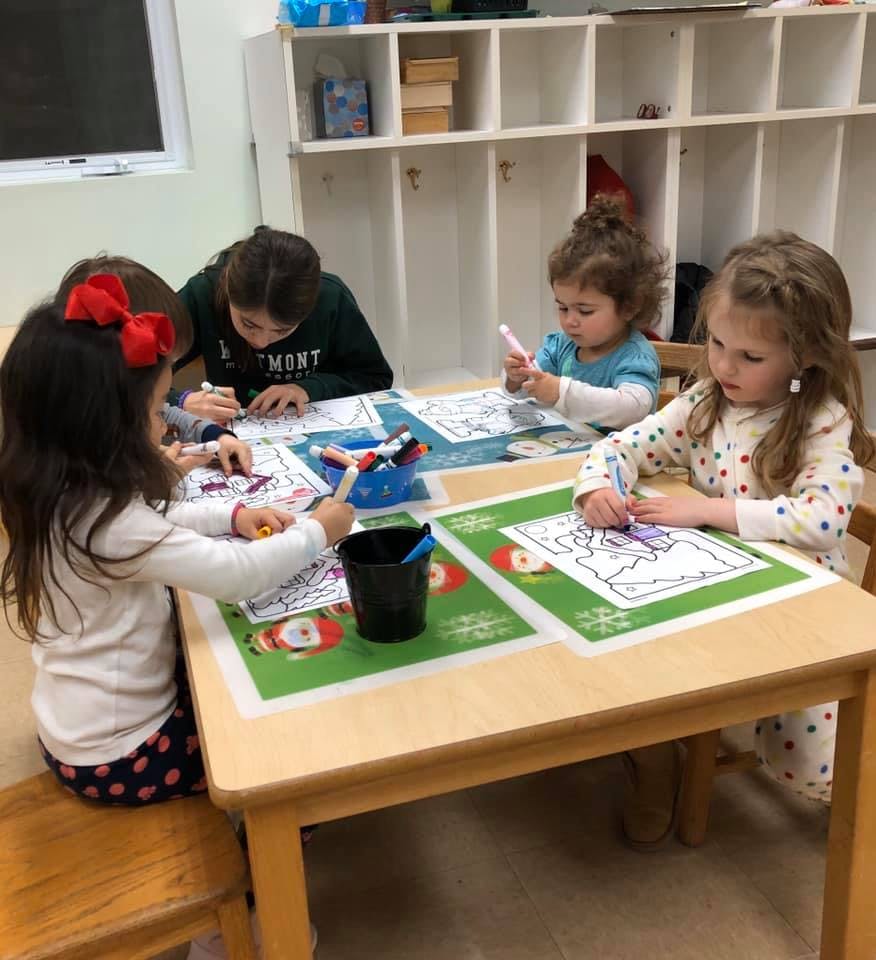 Children coloring at a table in a classroom