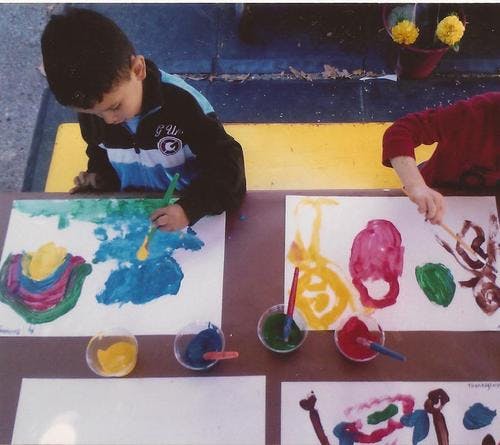 Two children painting at a table
