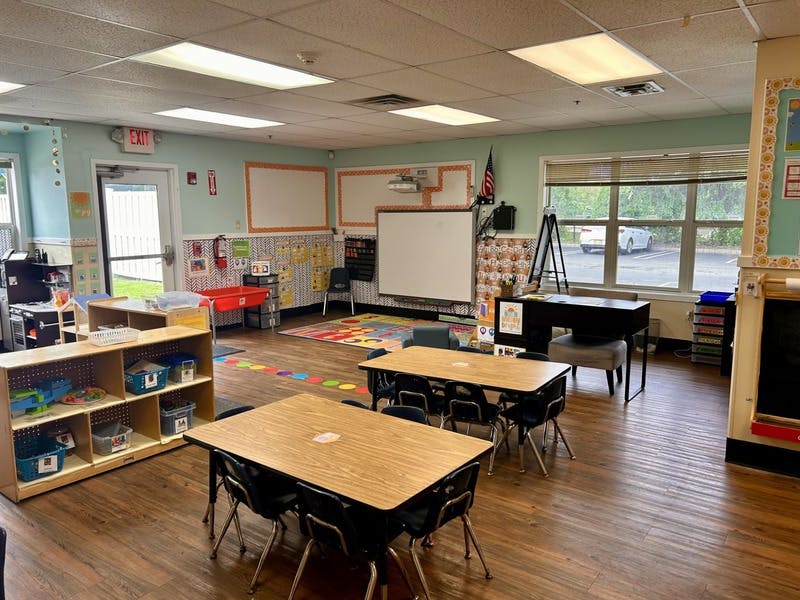 An empty classroom with small tables and chairs