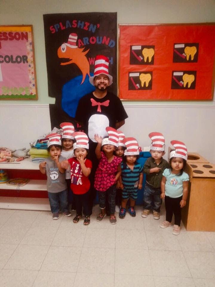 Adult and children wearing red and white striped hats in a classroom