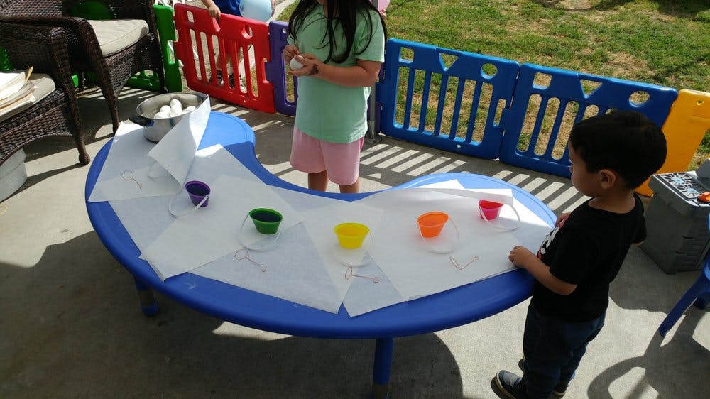 Two children at a table with colorful cups