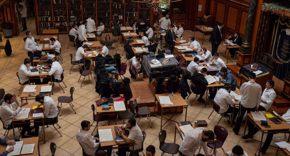 People studying together at desks in a large room with bookshelves