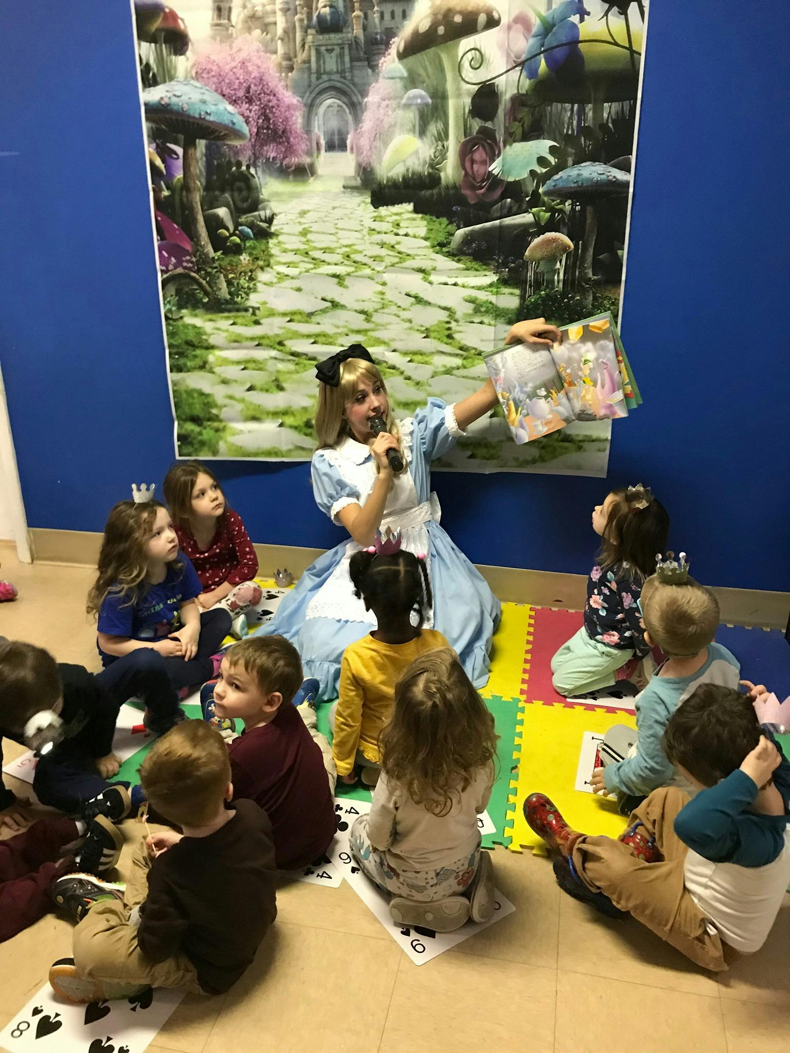 Person in costume reading a book to a group of children