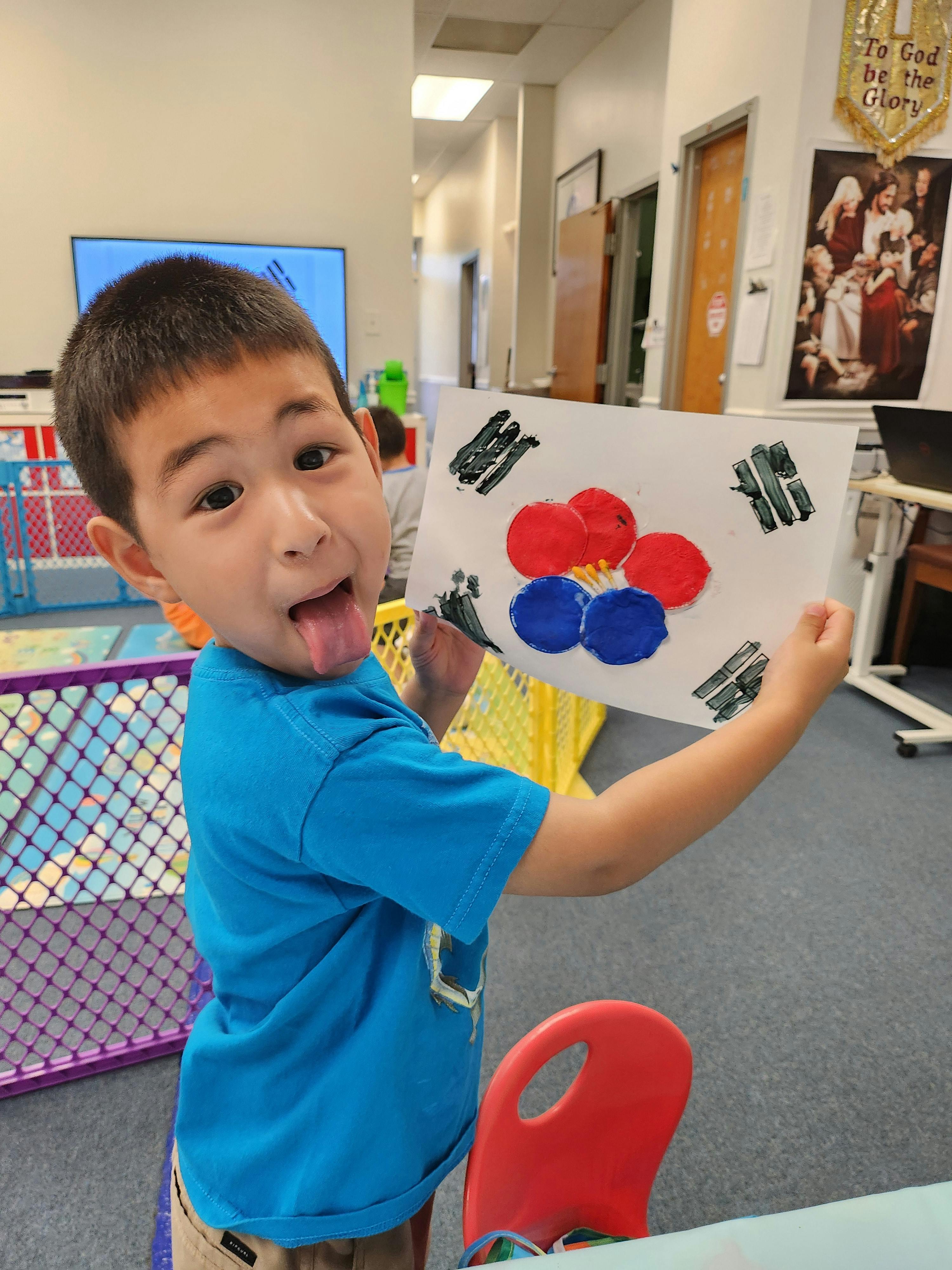 Child holding a drawing of the South Korean flag