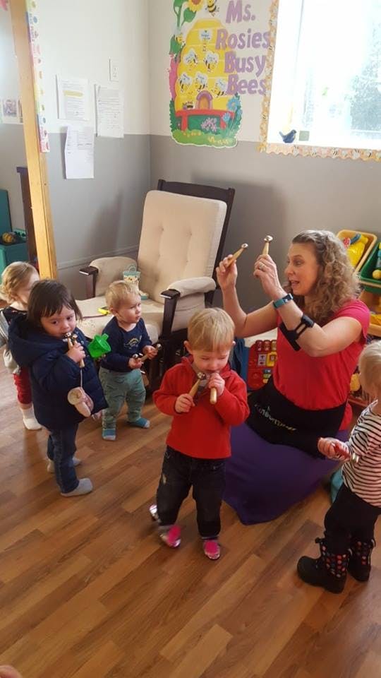 Adult and children playing with musical instruments in a classroom