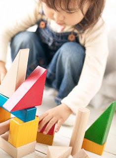 Child playing with colorful wooden blocks