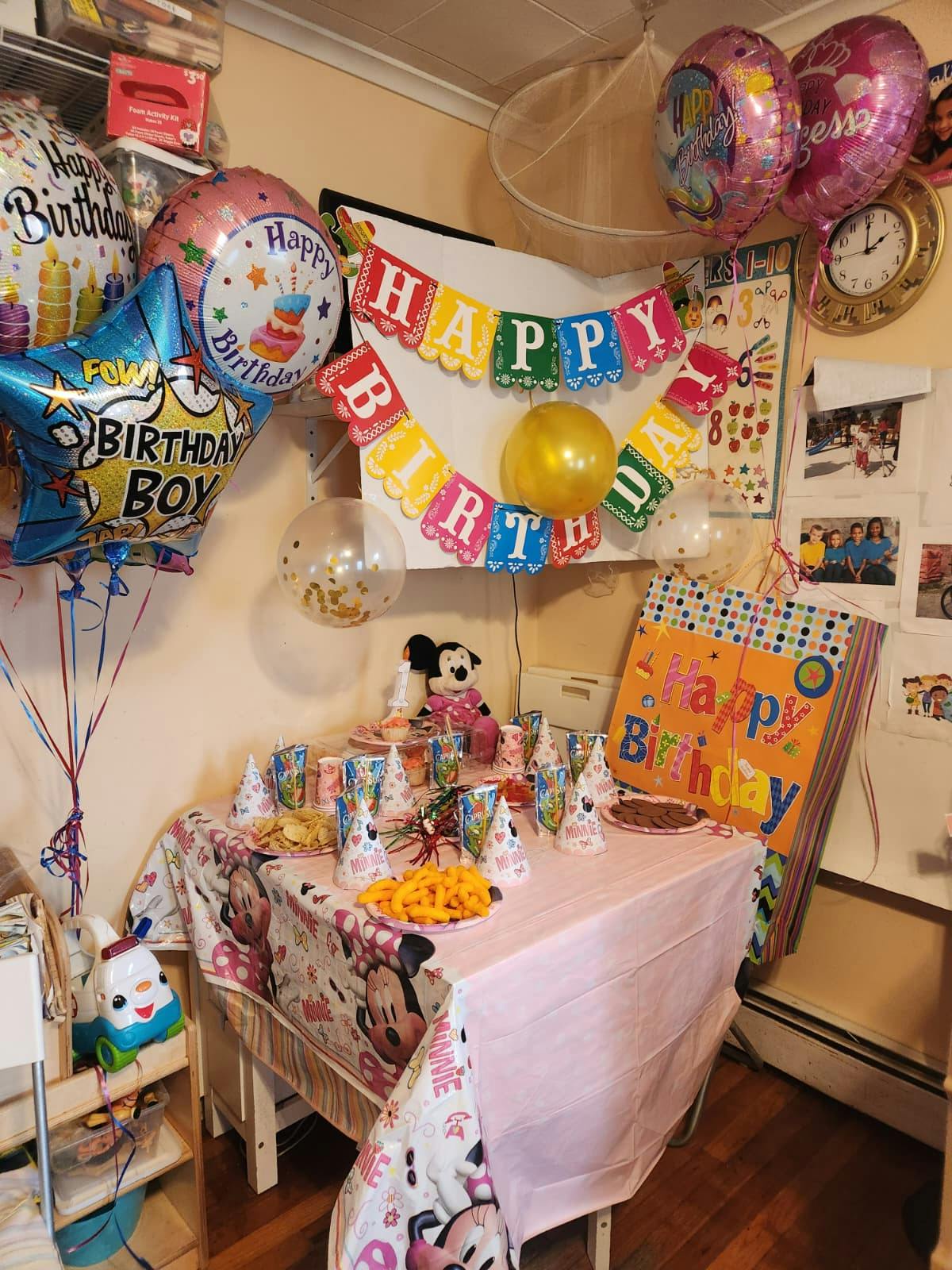Birthday party table decorated with Minnie Mouse theme and balloons