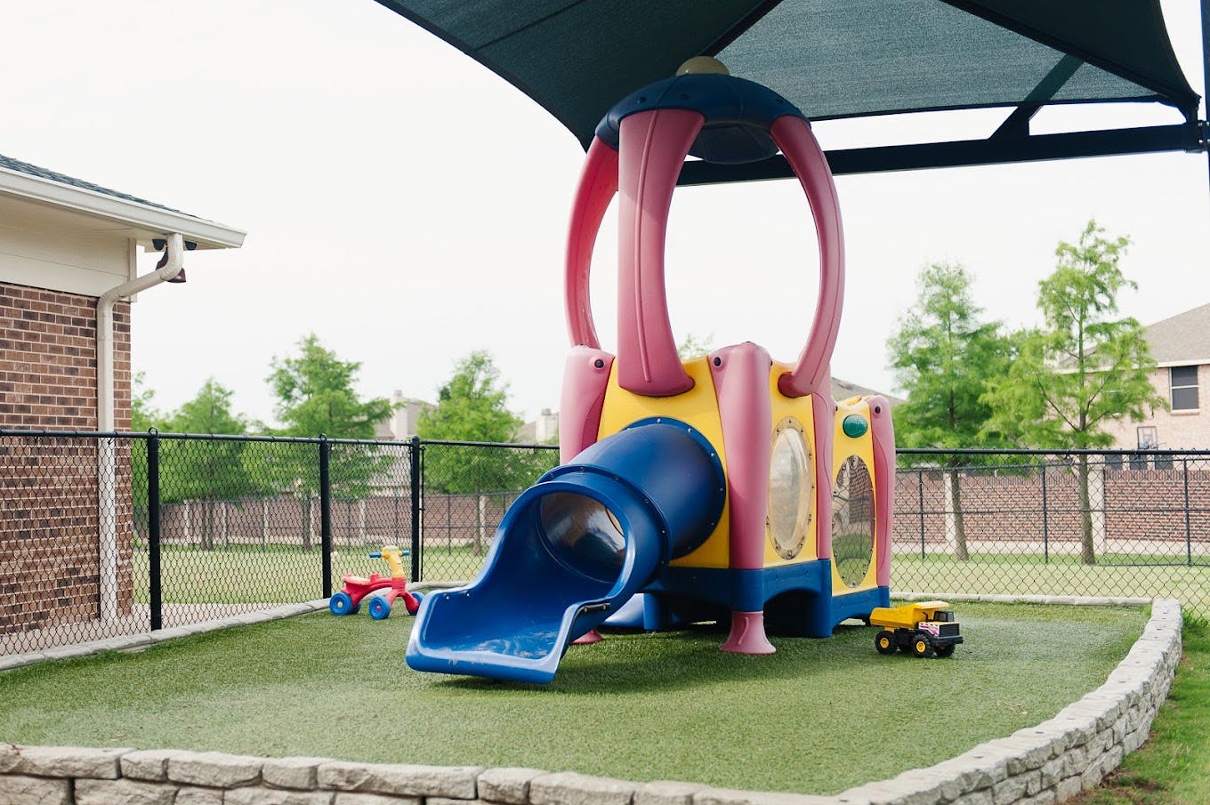 Colorful playground structure with a blue slide on artificial turf