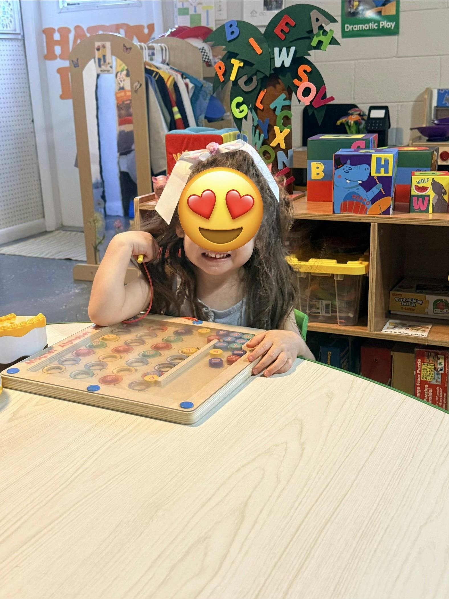 Child playing with a magnetic alphabet board in a classroom