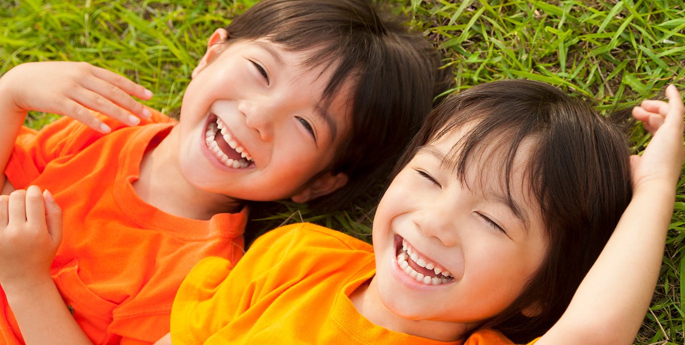 Two children lying on grass