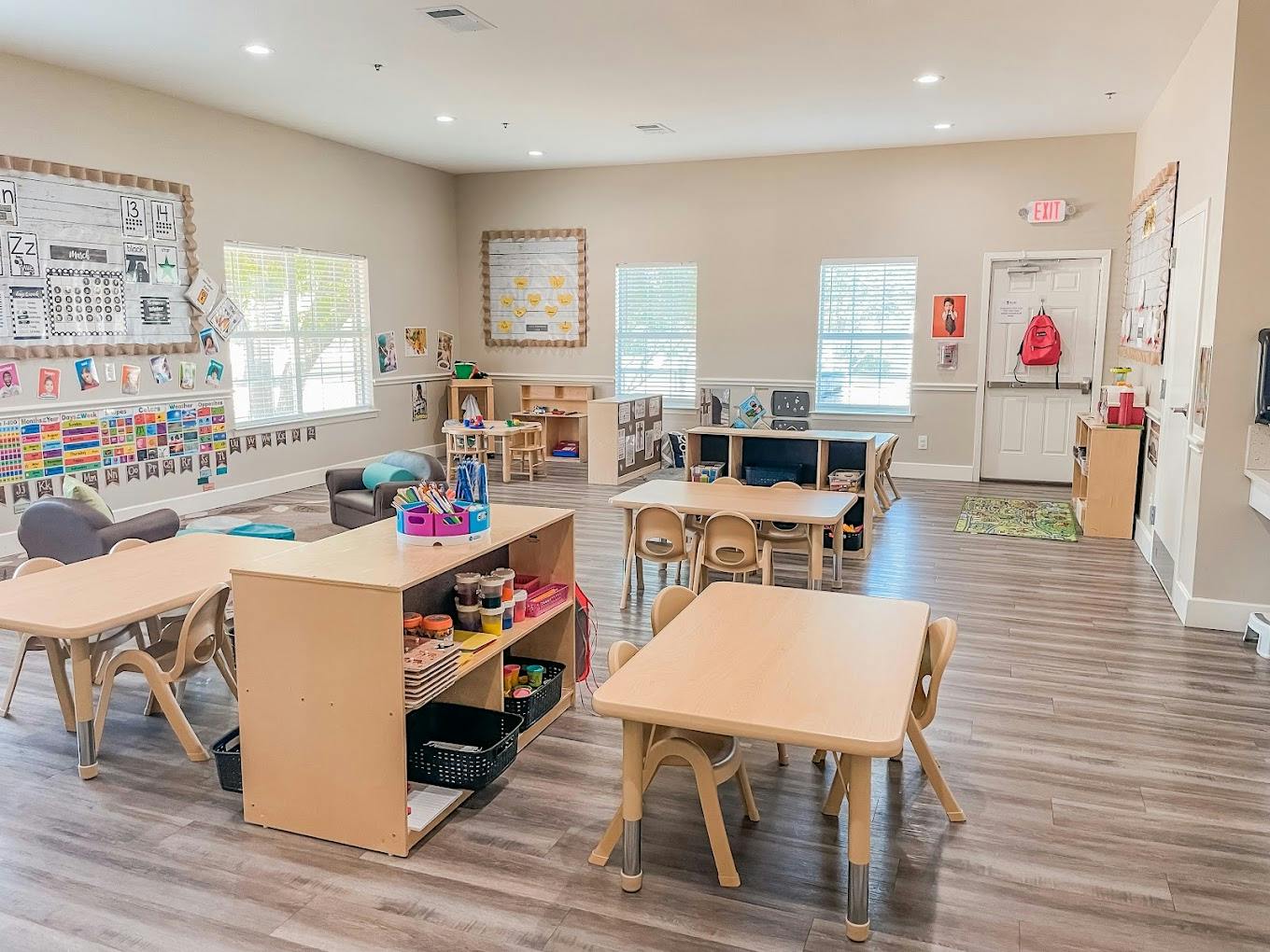 Empty preschool classroom with small tables and chairs