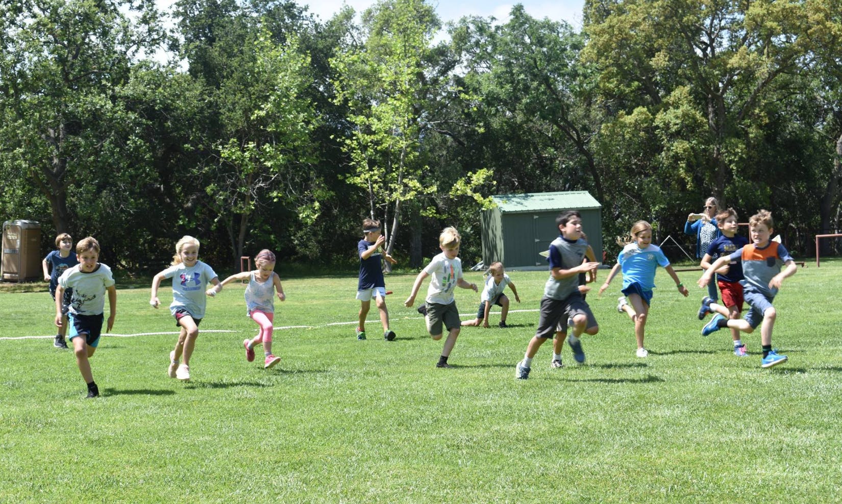 Group of children running on a grassy field