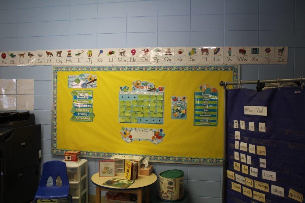 Classroom wall with a yellow bulletin board and alphabet chart