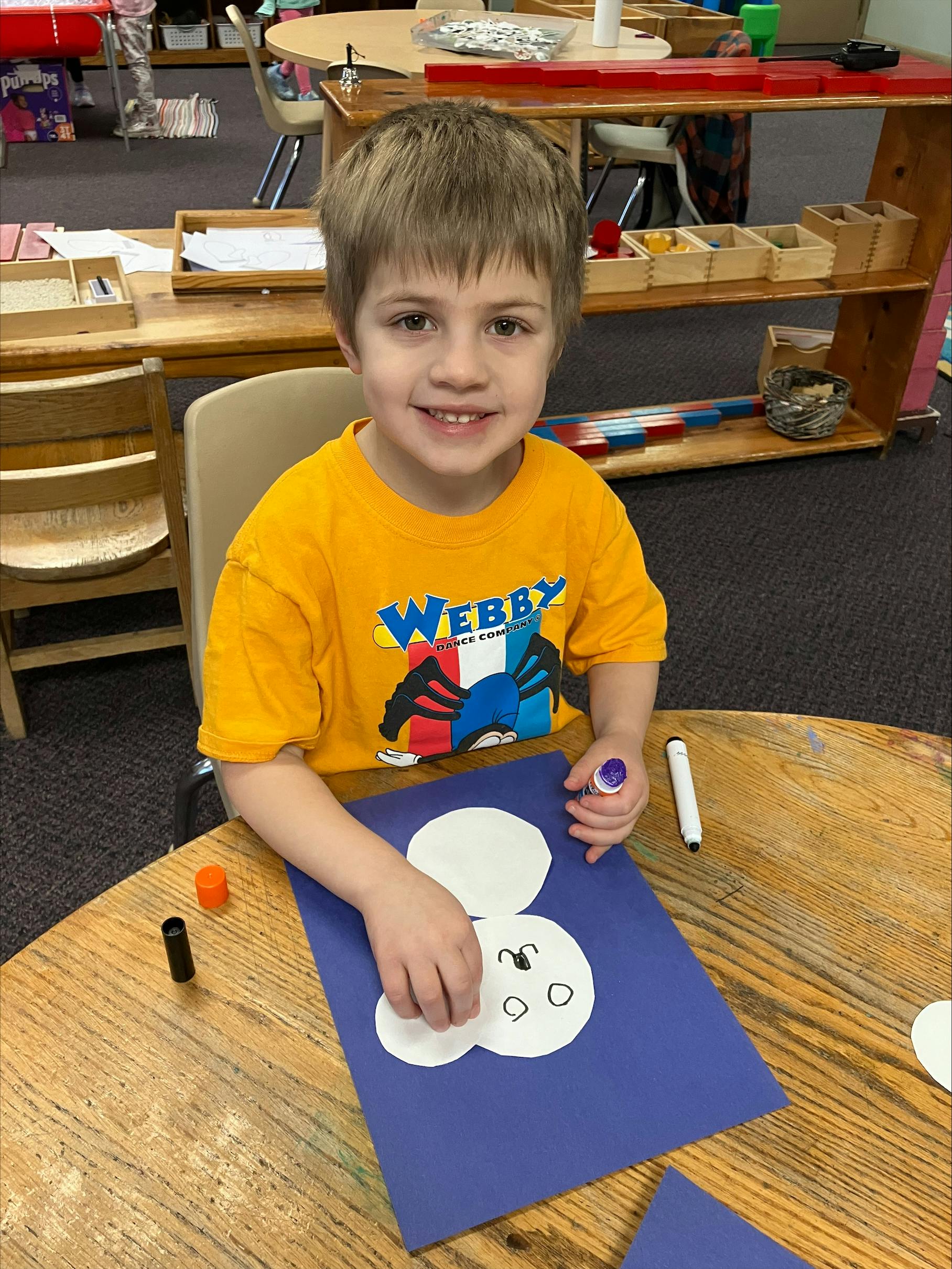 Child making a craft at a table