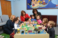 Adults and children playing with toys at a table