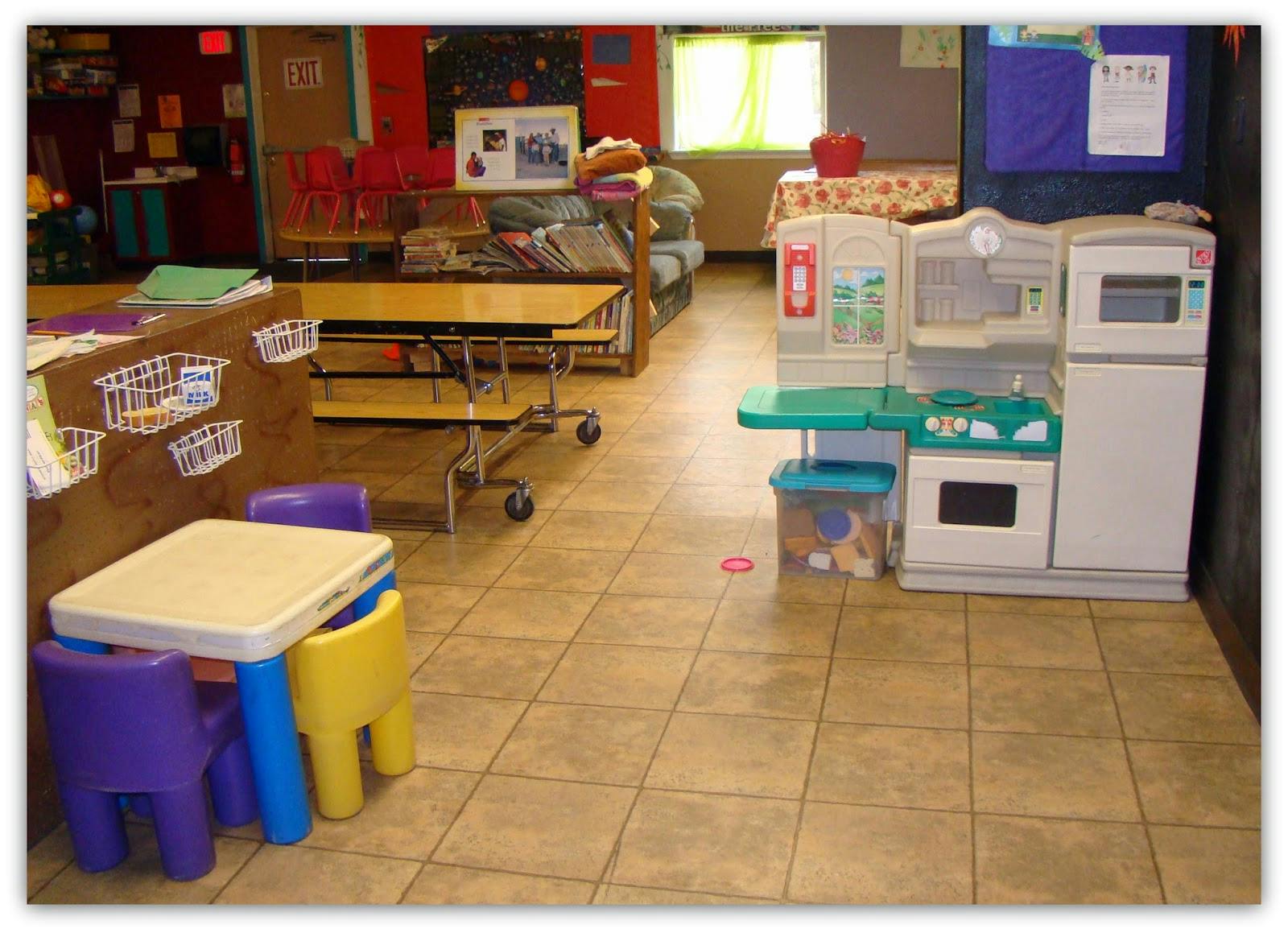 Children's play kitchen and small table with chairs in a room