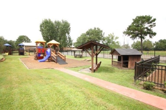 Outdoor playground with slides, swings, and small wooden structures