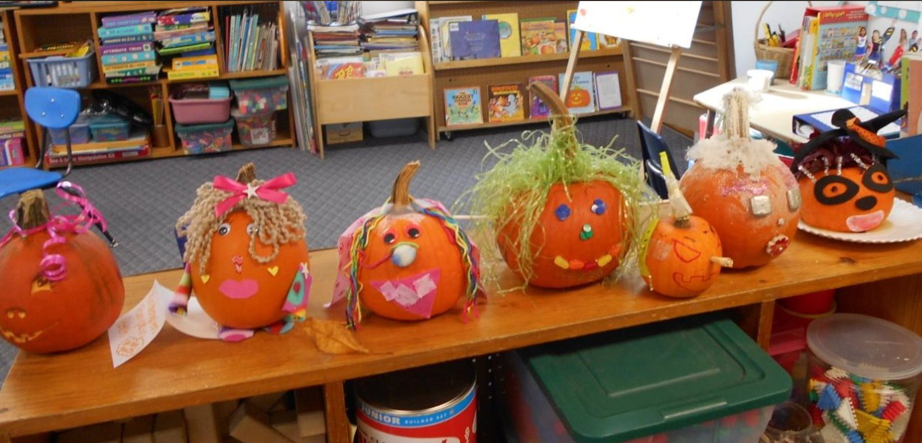 Decorated pumpkins on a shelf in a classroom