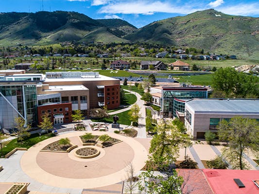 Aerial view of a university campus with buildings, pathways, and distant mountains