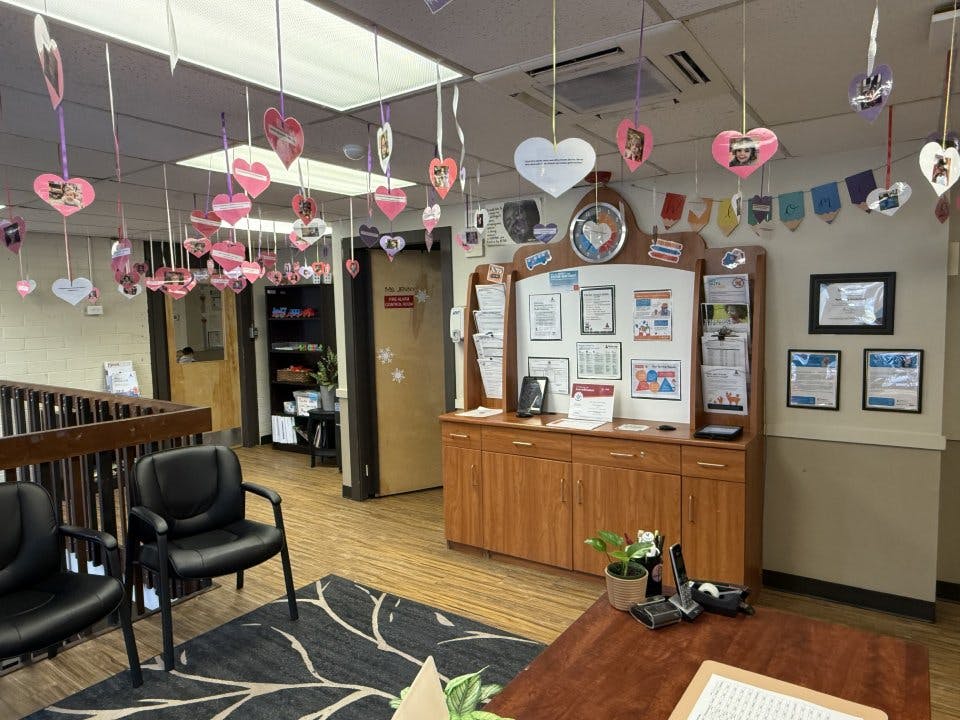 Lobby area with chairs, wooden cabinets, and heart decorations hanging from the ceiling