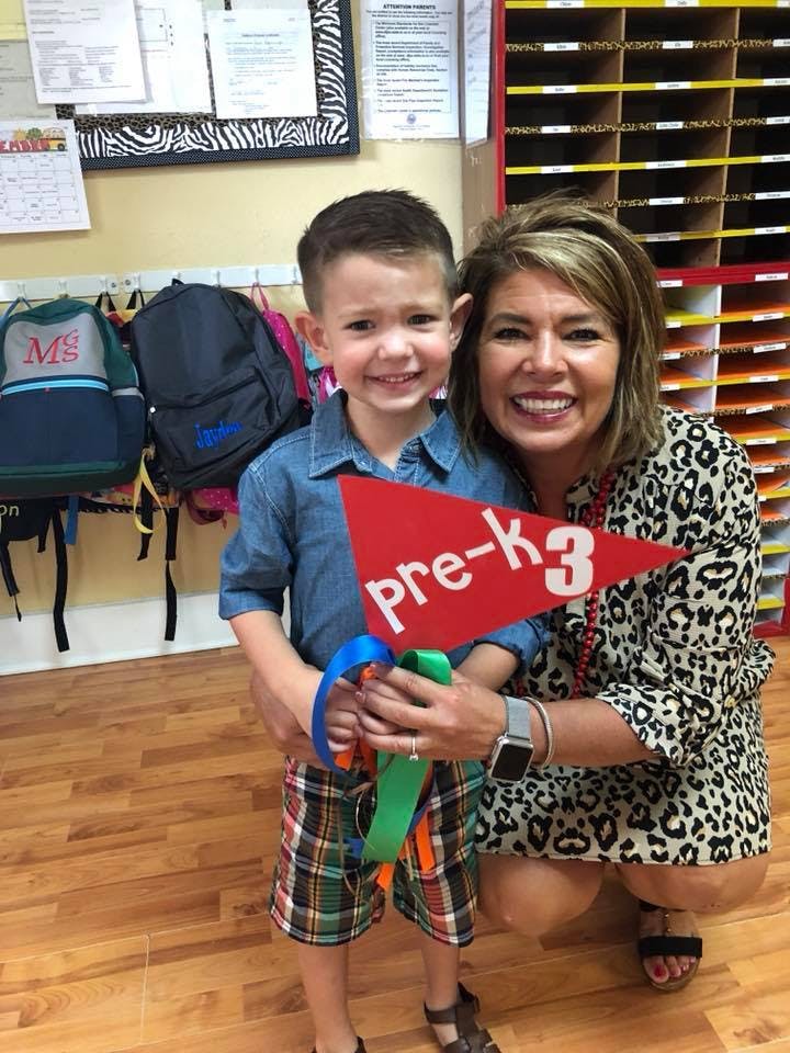 Adult and child holding a red flag that says "pre-k3"
