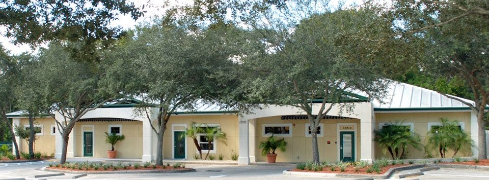 Building with multiple entrances and trees in front