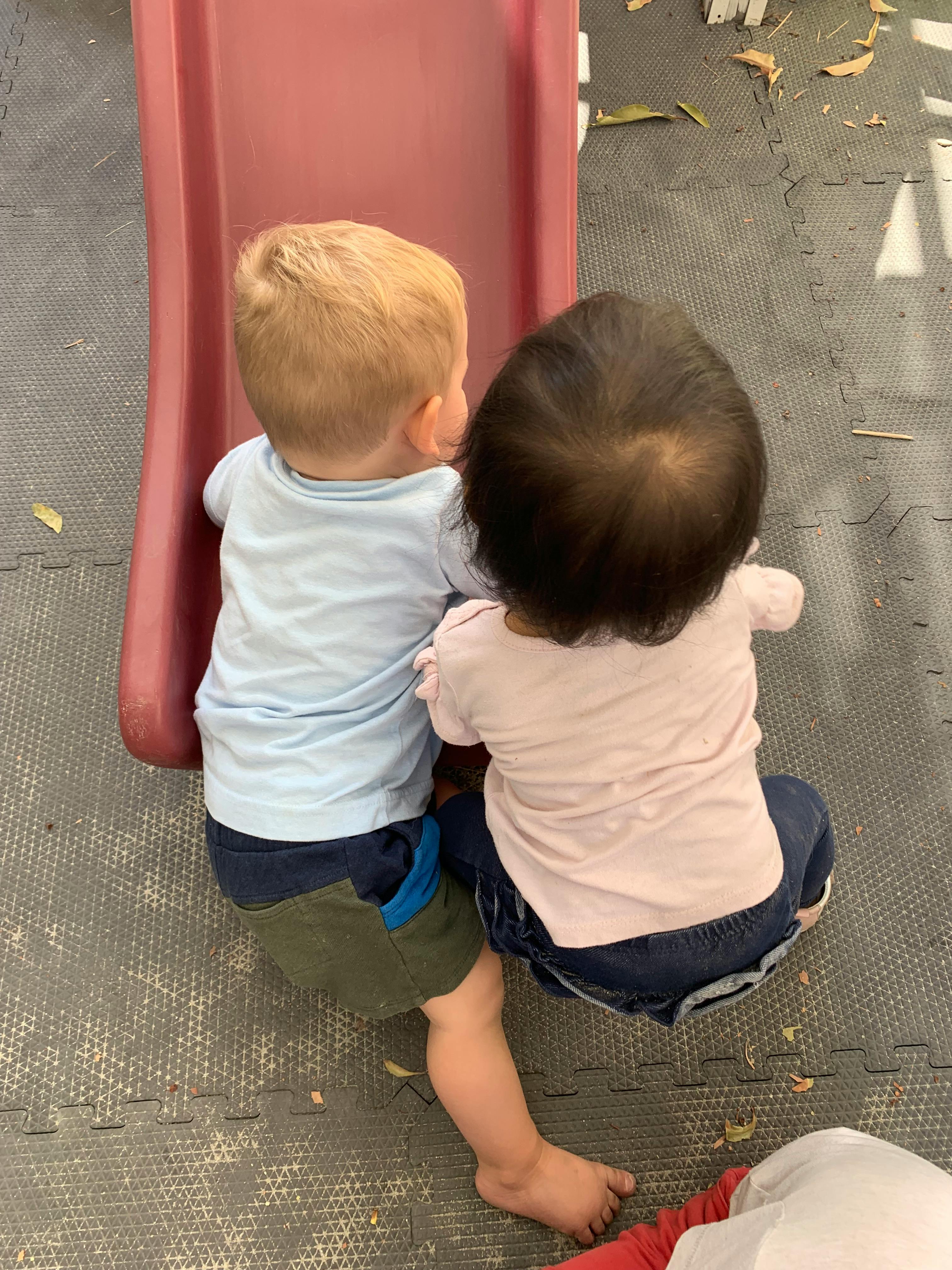 overhead view of two children on a red slide