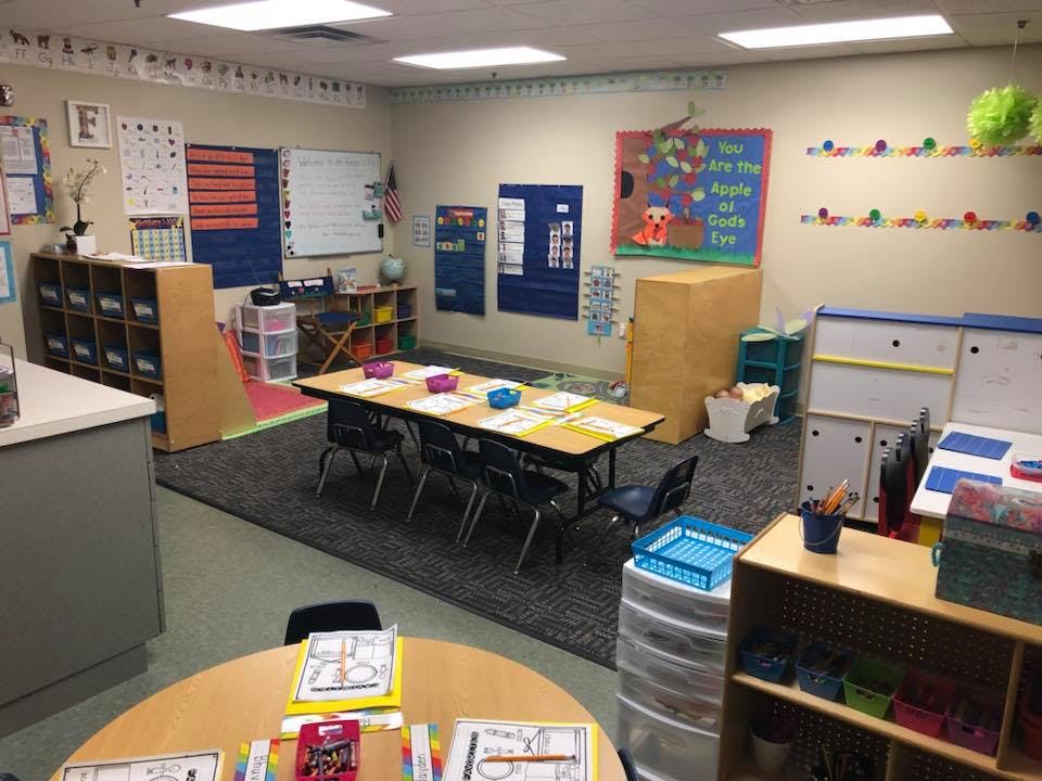 Empty classroom with tables, chairs, and learning materials