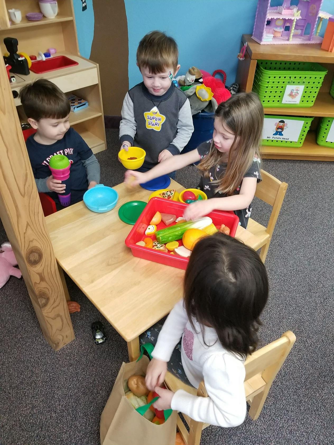 Children playing with toy food at a table
