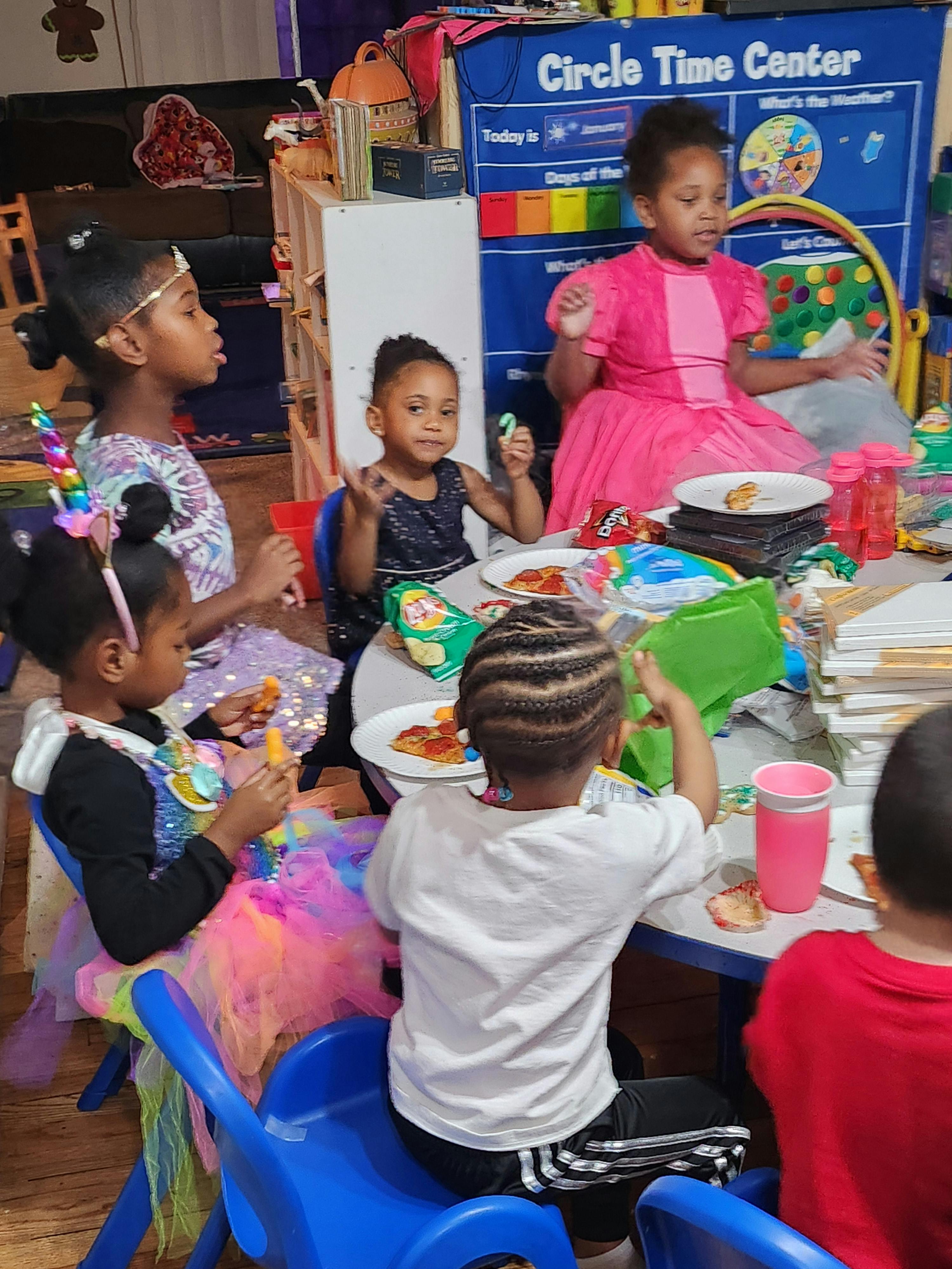 Children sitting at tables eating in a classroom