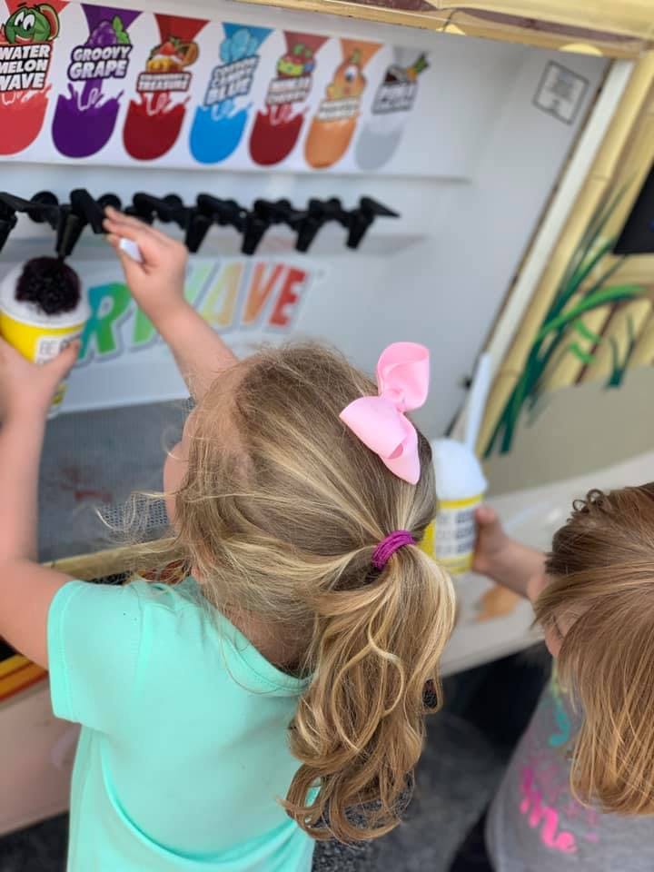 Child filling a cup from a drink dispenser