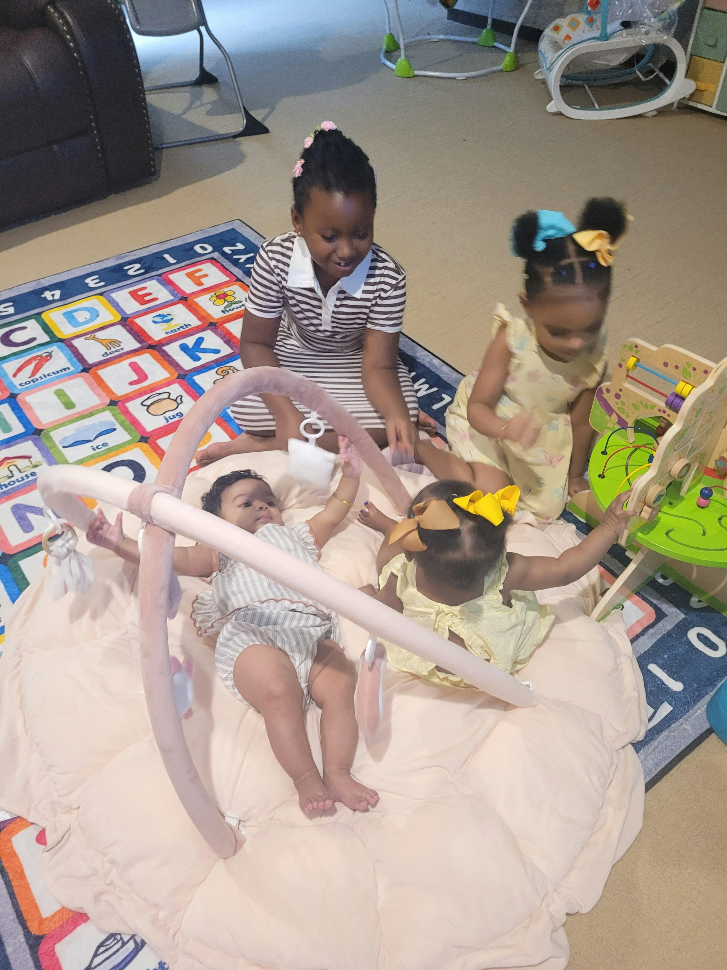 Three children playing together on a nursery rug