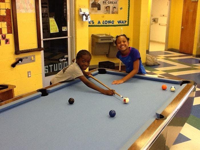 Two children playing pool