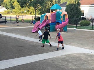 Children playing on a playground with a colorful slide structure