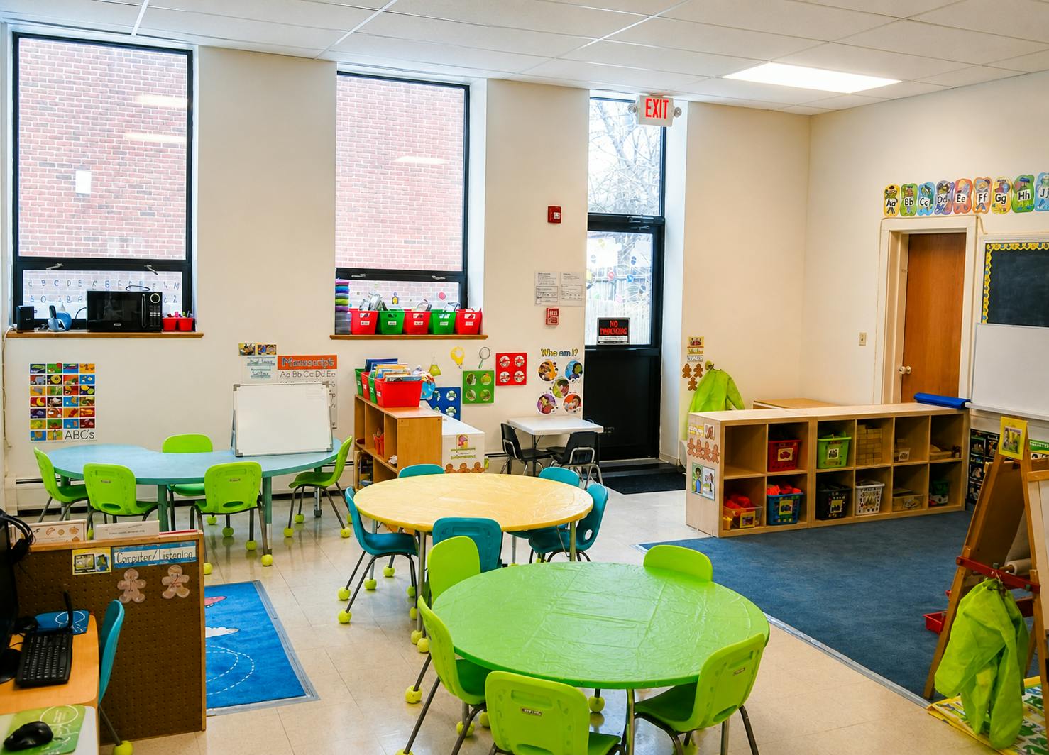 Classroom with child-sized tables and chairs, shelves, and educational posters