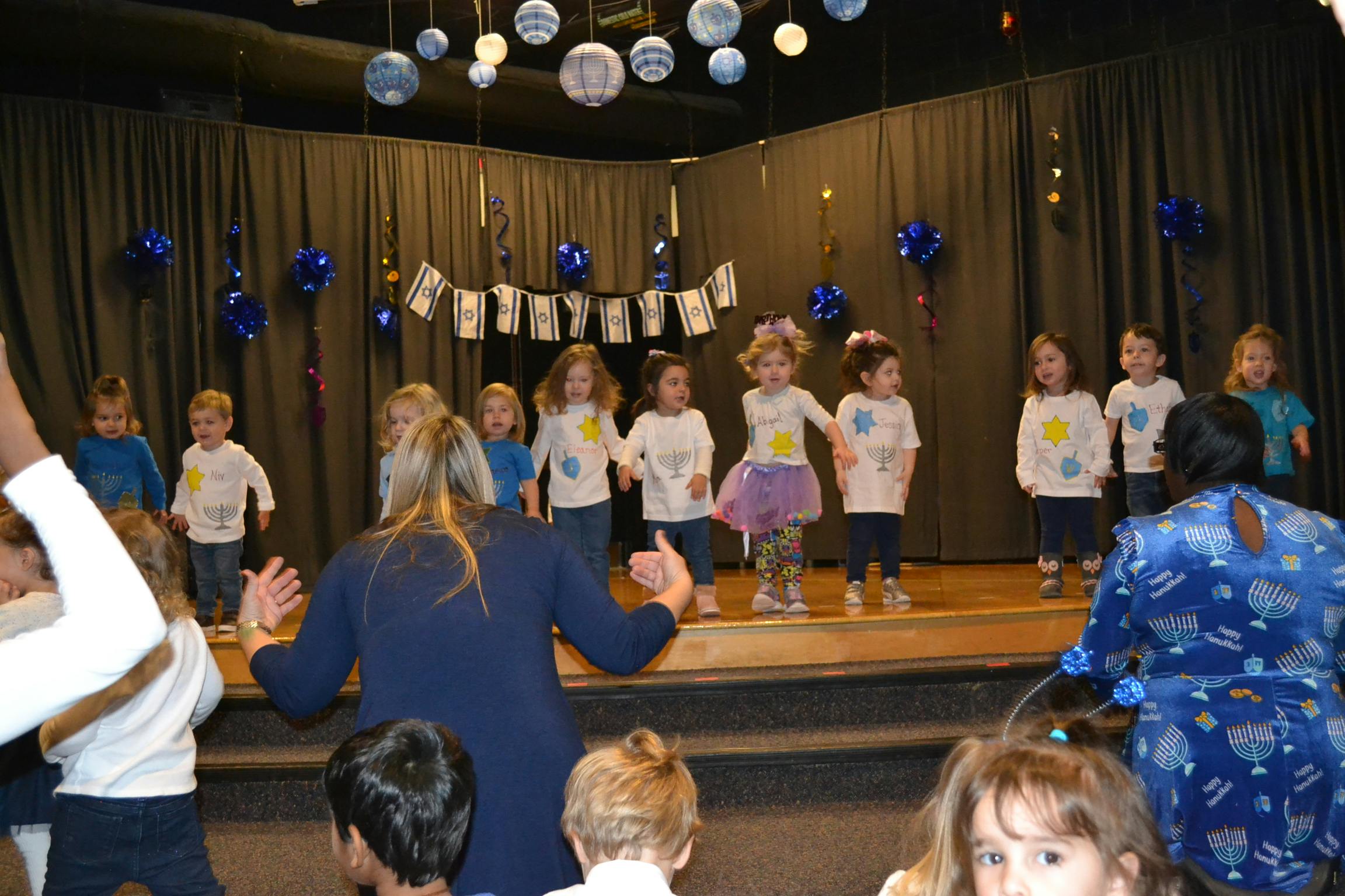 Adults and children on a stage with decorations