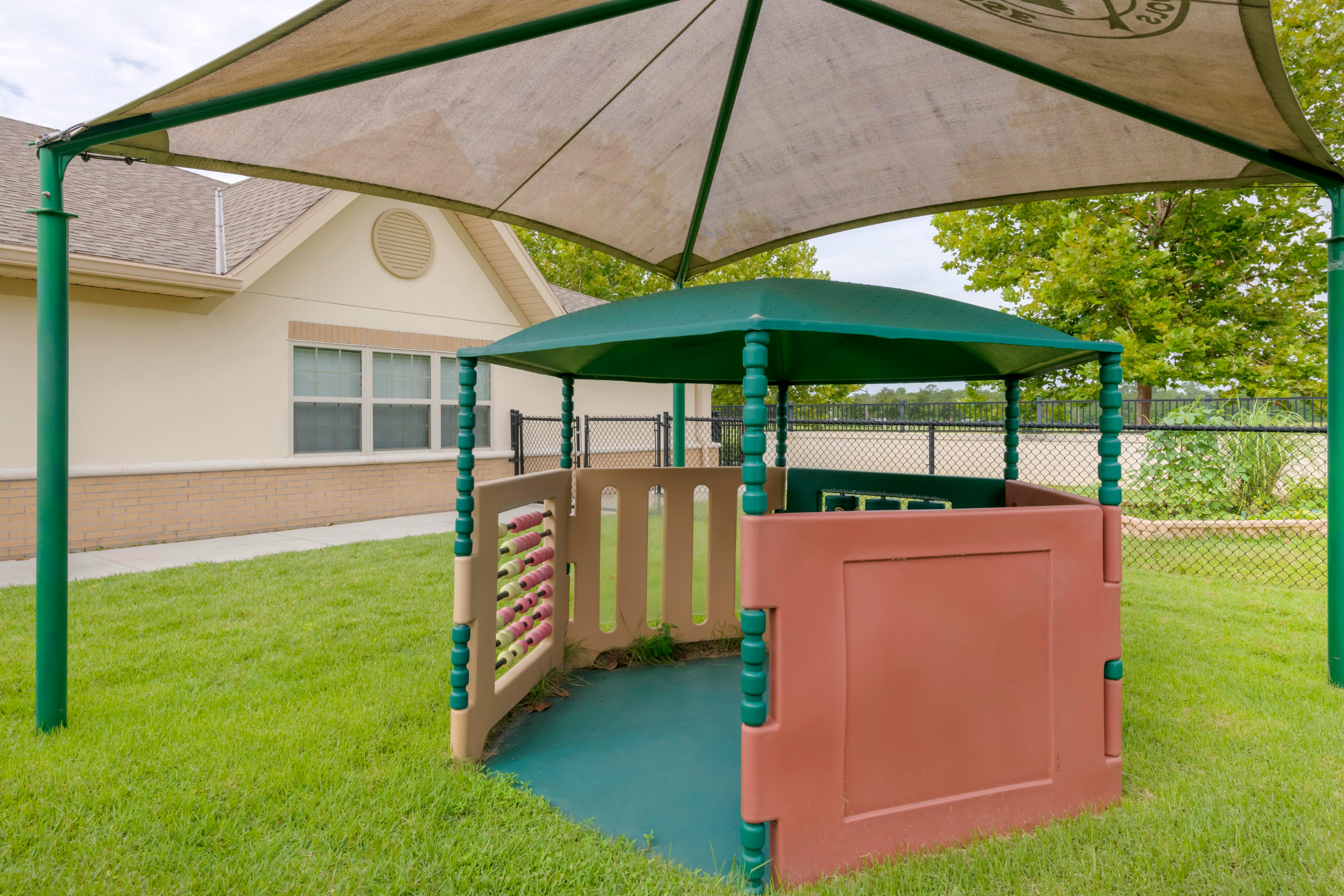 Small outdoor play structure with an abacus under a large sunshade