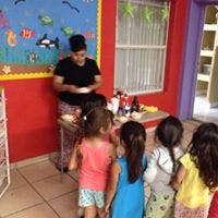 Person serving food to children in a classroom