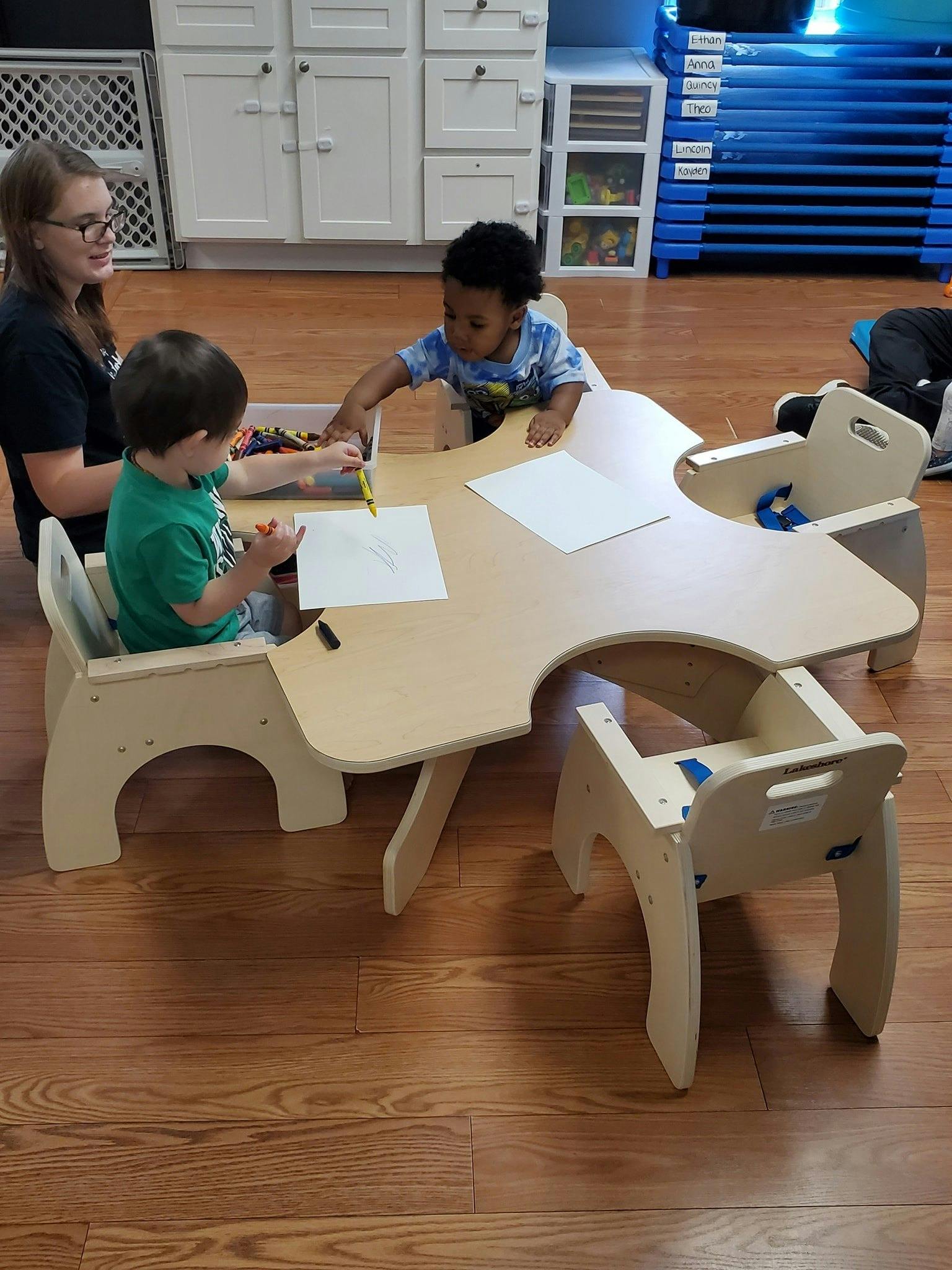 Person and two children drawing at a table