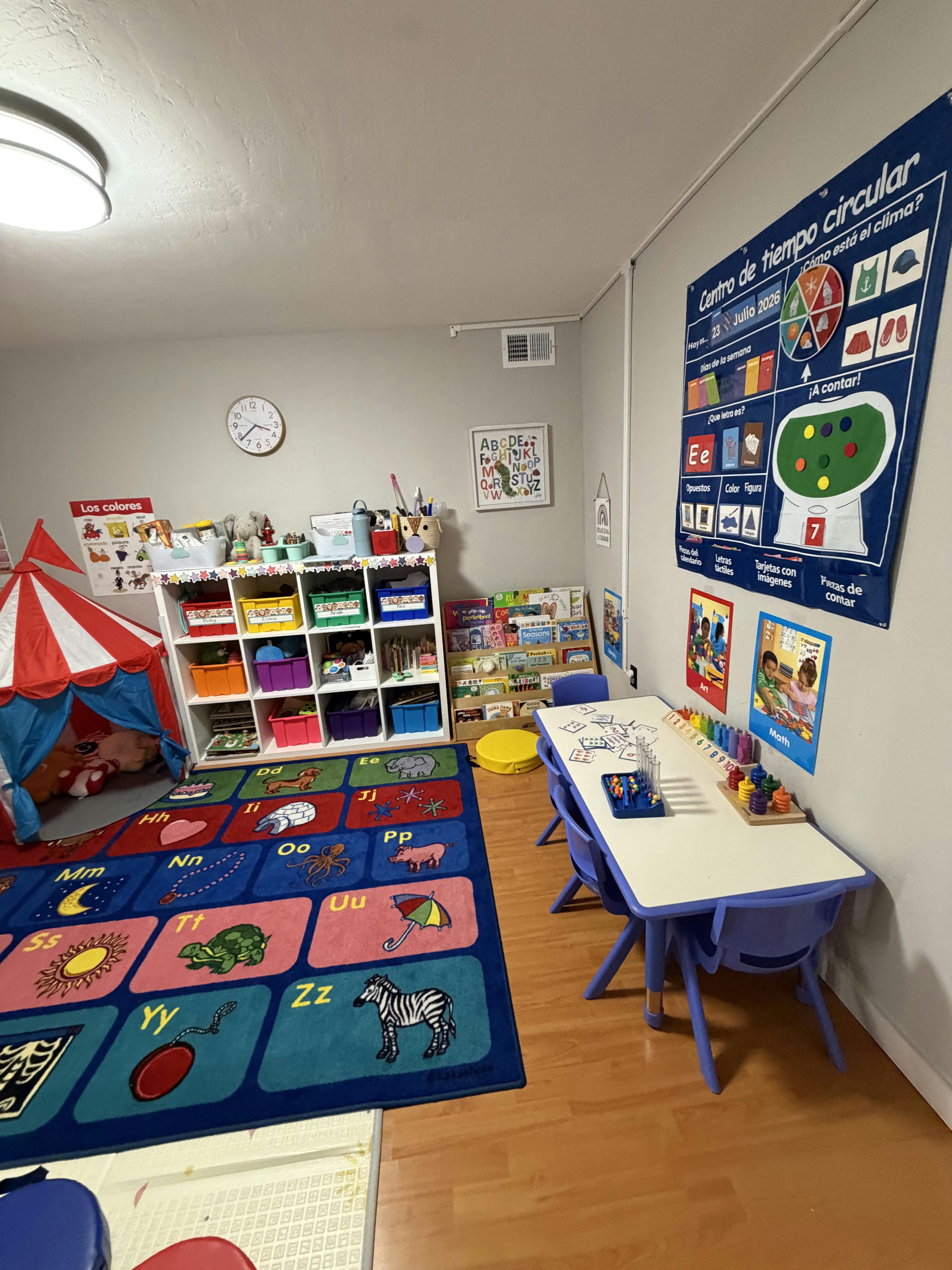 Classroom interior with educational toys, a play tent, and a learning rug