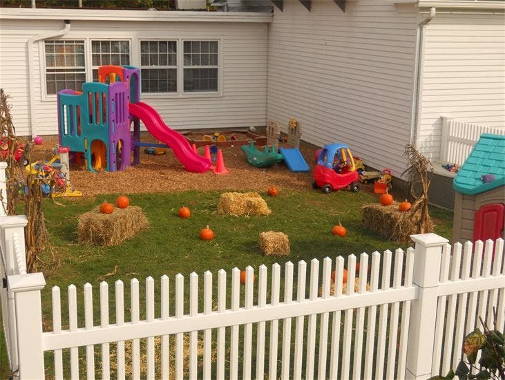 Playground with slide, playhouse, and pumpkins on hay bales