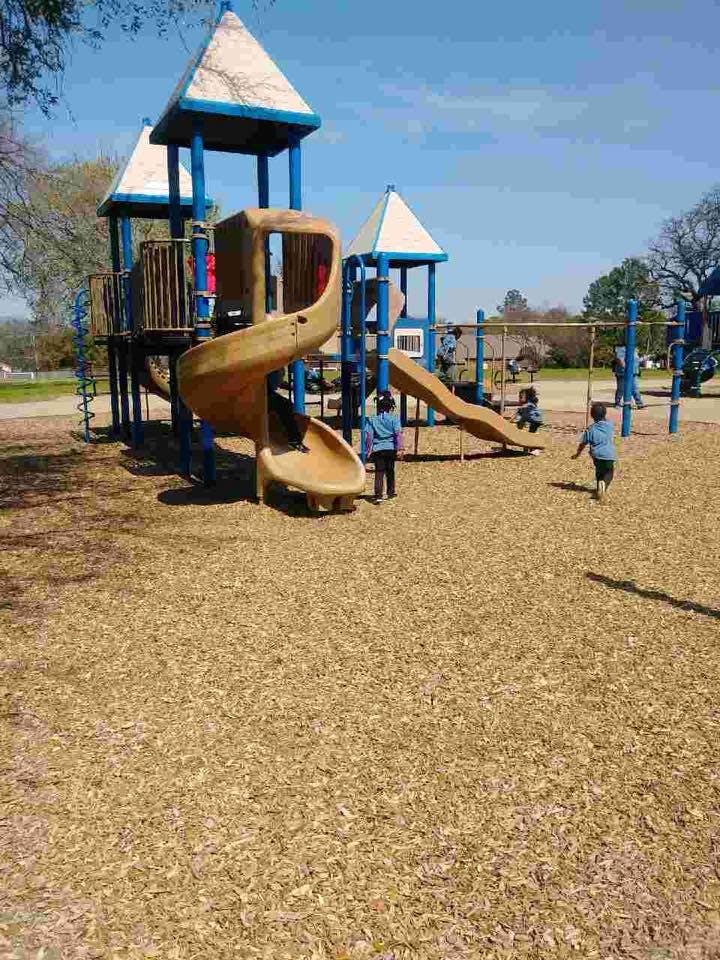 Children playing on a playground with slides and swings