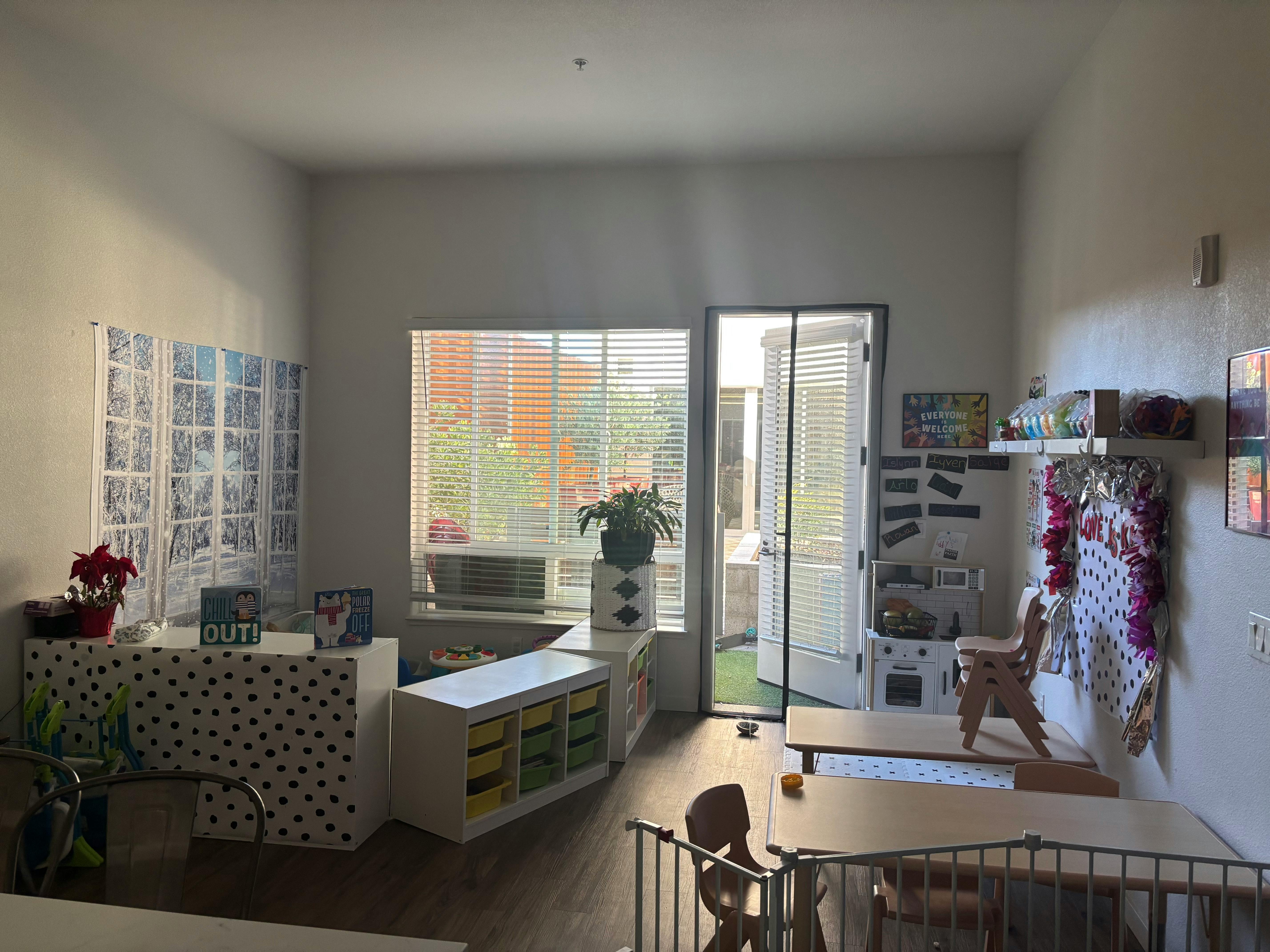 Playroom with windows, small tables, and toy kitchen