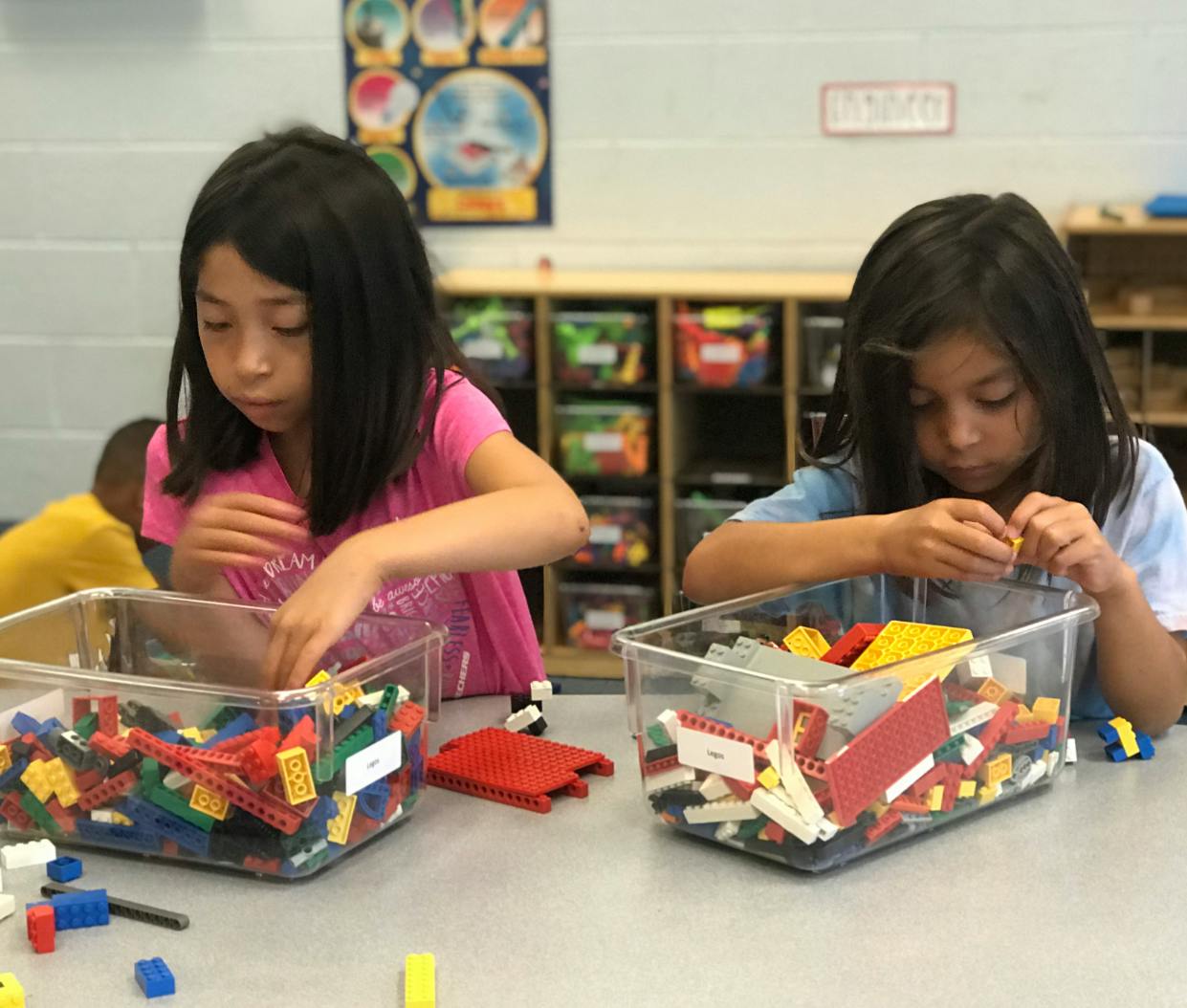 Two children playing with building blocks in a classroom